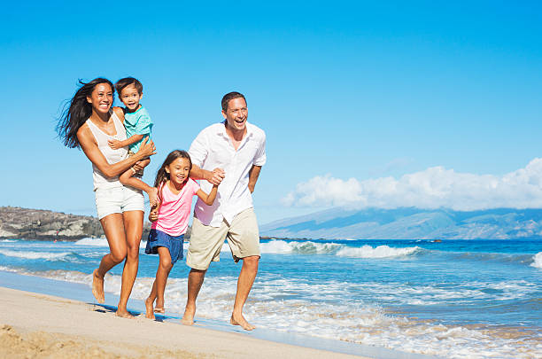 happy mixed race family of four on the beach